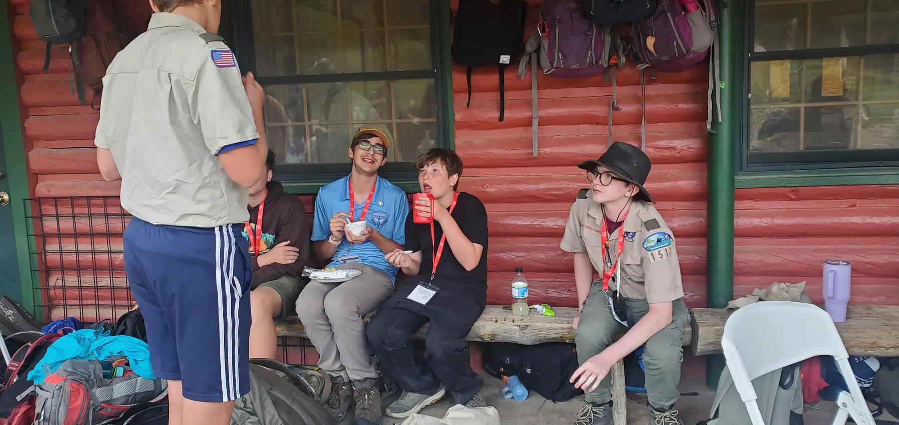 Scouts relaxing and talking together outside a camp cabin