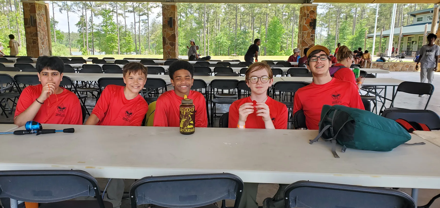 Five Troop 1513 Scouts smiling together at a camp dining table