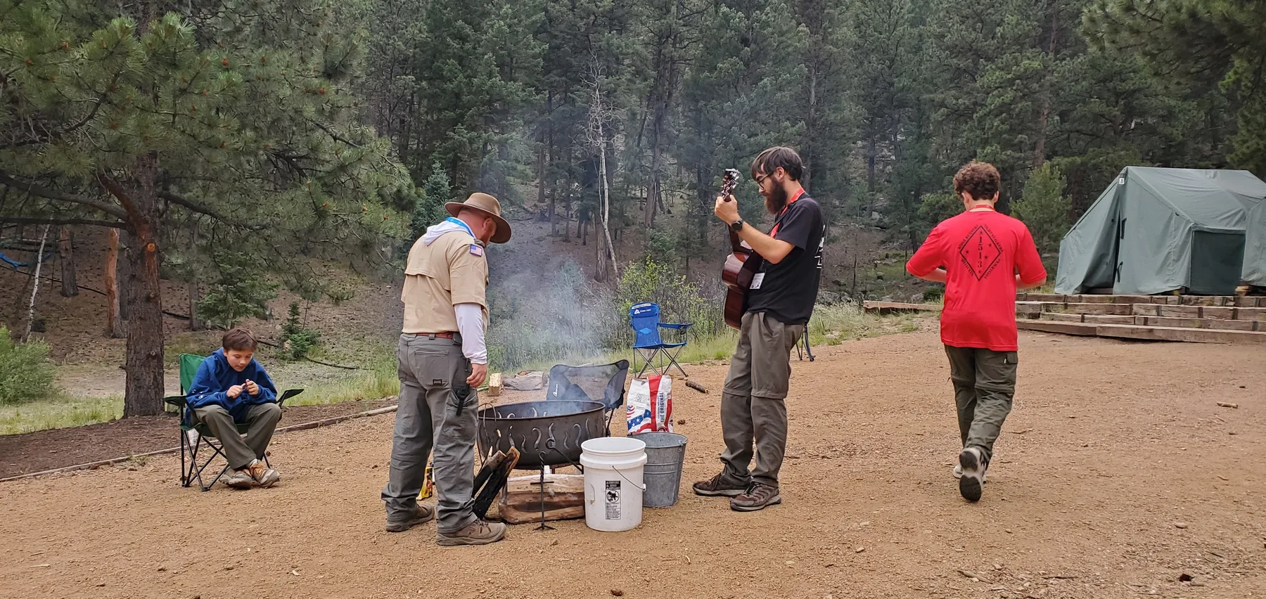 Troop 1513 Scouts and an adult leader preparing food together at camp