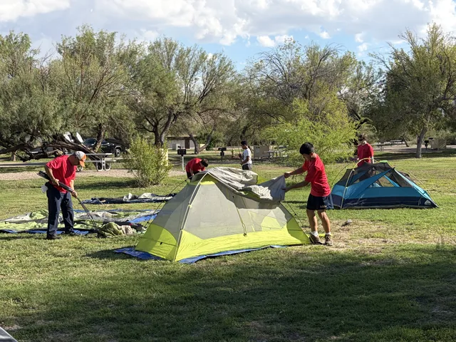 Troop 1513 Scouts handling tent fabric and poles together at camp