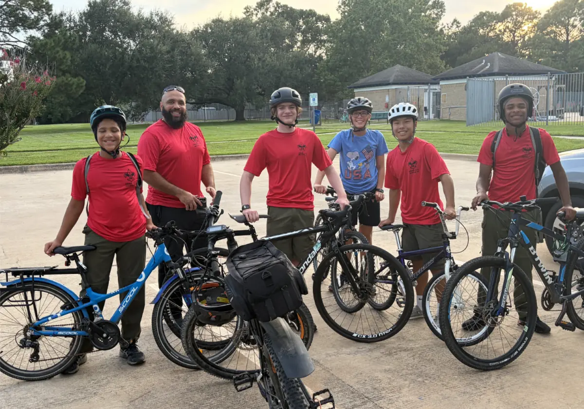 Troop 1513 Scouts and an adult volunteer with their bicycles after riding at Exploration Green